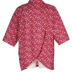 Women's short-sleeved polo shirt, red with navy and white dots. Viewed from the back, it shows the petal back design for easy dressing