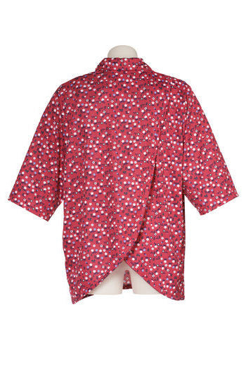 Women's short-sleeved polo shirt, red with navy and white dots. Viewed from the back, it shows the petal back design for easy dressing