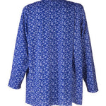 Rear view of the petal back split closure on the women's long sleeve adaptive blouse. Fabric is blue and white floral pattern